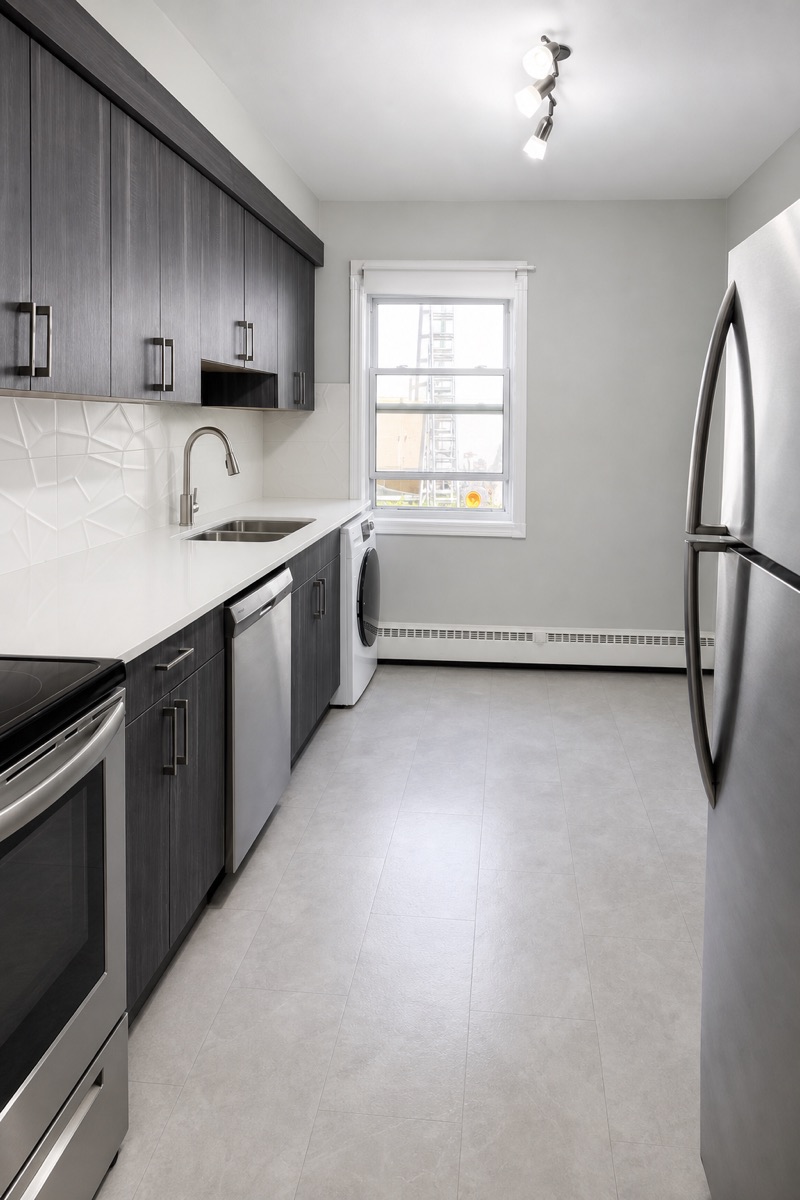 Galley kitchen with clean stainless appliances and freshly mopped floors after a NeatNow clean