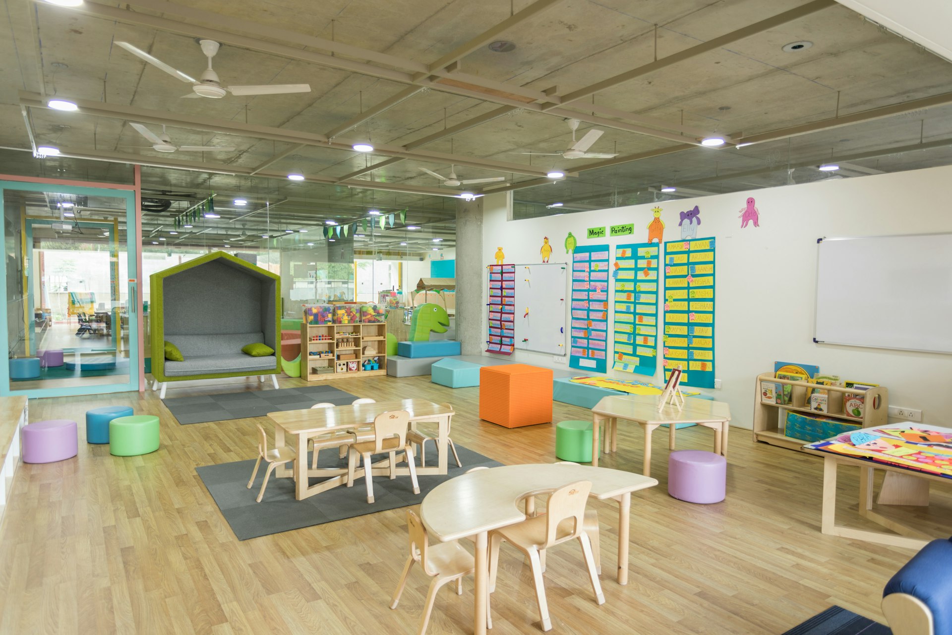 Clean, bright daycare classroom with child-sized furniture and play area